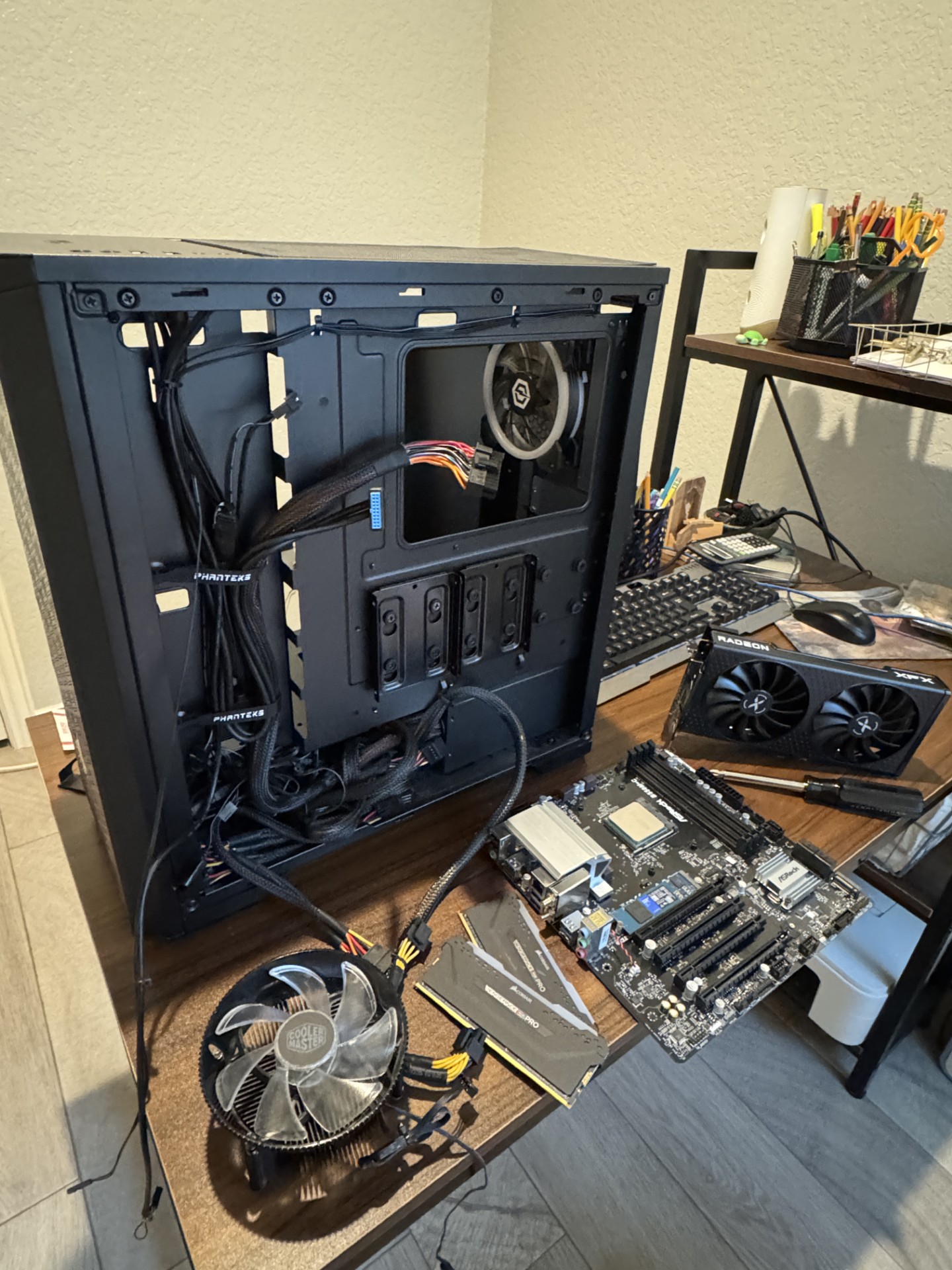 Motherboard, GPU, and cooler laid out on a desk during troubleshooting